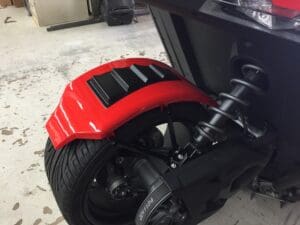 A red motorcycle tire with black rim and a black wheel.