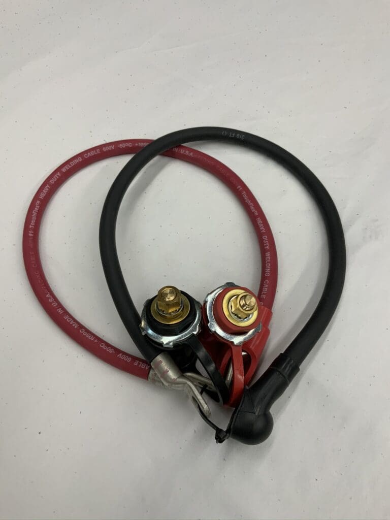 A pair of red and black cables with electrical plugs.