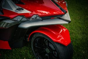 A close up of the side wheel on a red motorcycle.