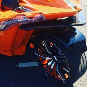 A close up of the wheel on an orange car