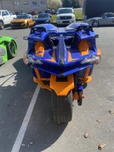A blue and orange motorcycle parked in the parking lot.