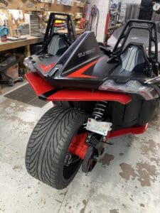 A red and black motorcycle parked in a garage.