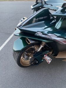 A green motorcycle parked in the middle of a parking lot.