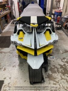 A yellow and white motorcycle parked in a garage.