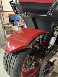 A red motorcycle is parked in the garage.